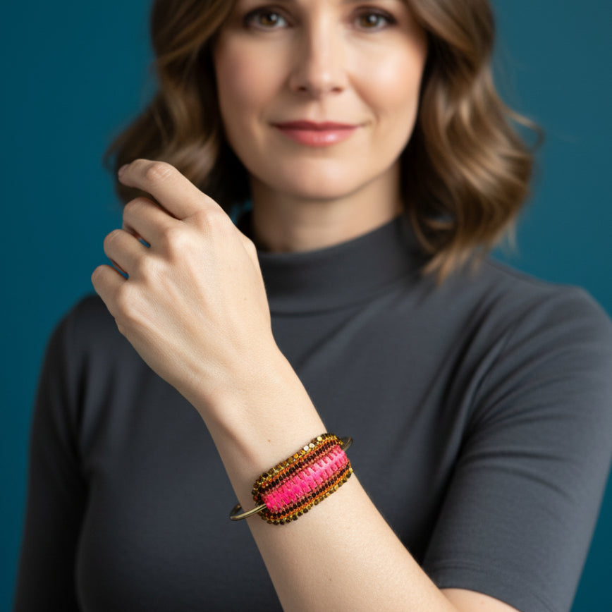 Colorful beaded bracelet on a clear stand against a gray background