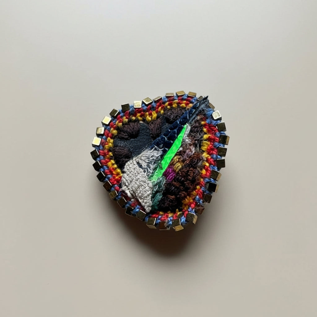 Colorful beaded brooch on a textured gray background