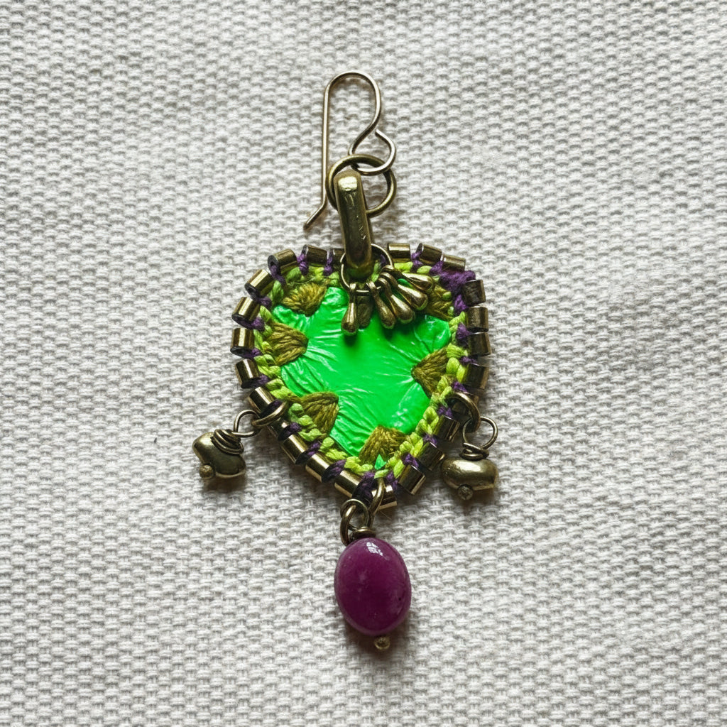 Decorative keychain with green and gold design on a textured white background