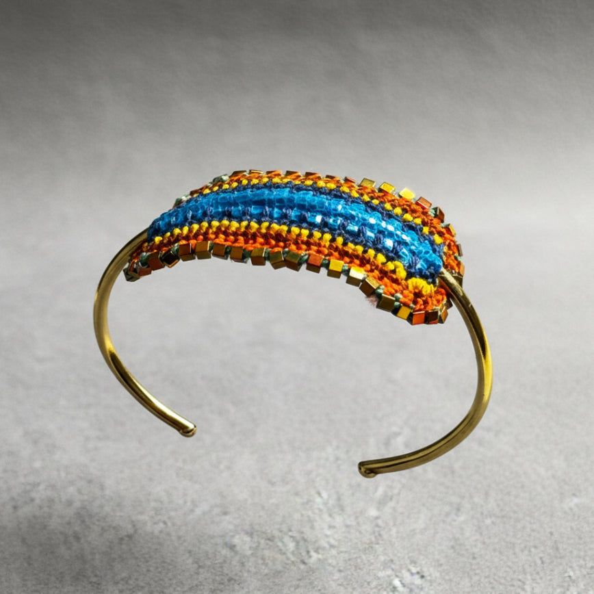 Multicolored beaded headband on a clear stand with a gray background