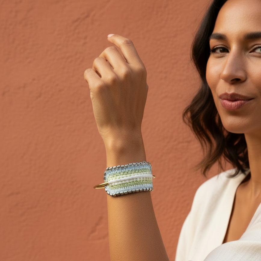 Multistrand beaded bracelet with gold clasp on a textured fabric background