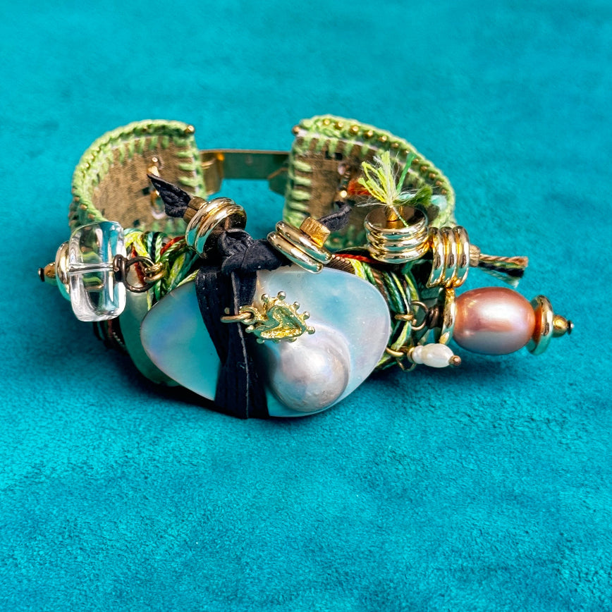 Decorative bracelet with pearls and beads on a turquoise background
