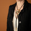 Mannequin wearing a black garment with a decorative necklace featuring a heart-shaped pendant.