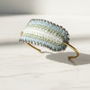 Beaded headband with a gradient of colors on a light gray surface