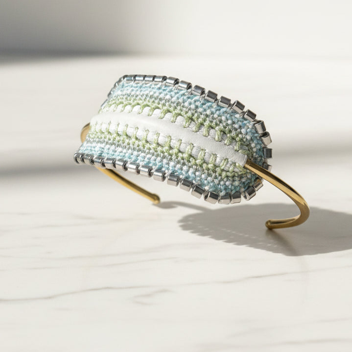 Beaded headband with a gradient of colors on a light gray surface