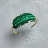 Green beaded headband on a gray surface