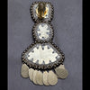 Decorative silver earring with intricate design on a gray background