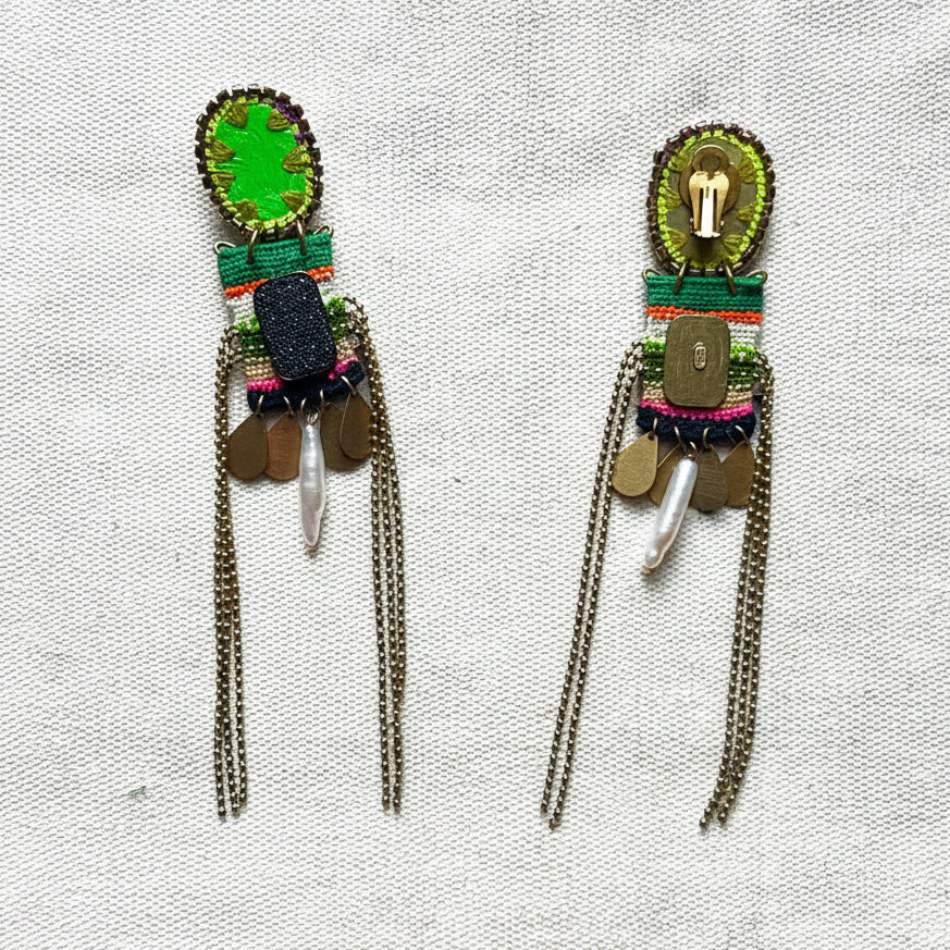 Pair of colorful beaded earrings on a textured fabric background
