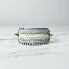 Beaded cuff bracelet with gold accents on a light gray surface