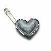 Heart-shaped brooch with metallic beads on a textured gray background