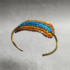 Multicolored beaded headband on a clear stand with a gray background