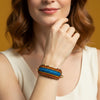 Multicolored beaded headband on a clear stand with a gray background