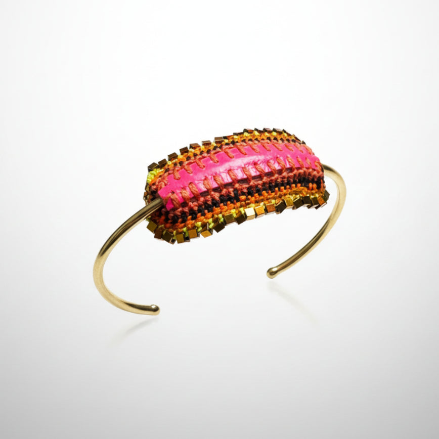 Beaded bracelet with pink and gold accents on a gray background