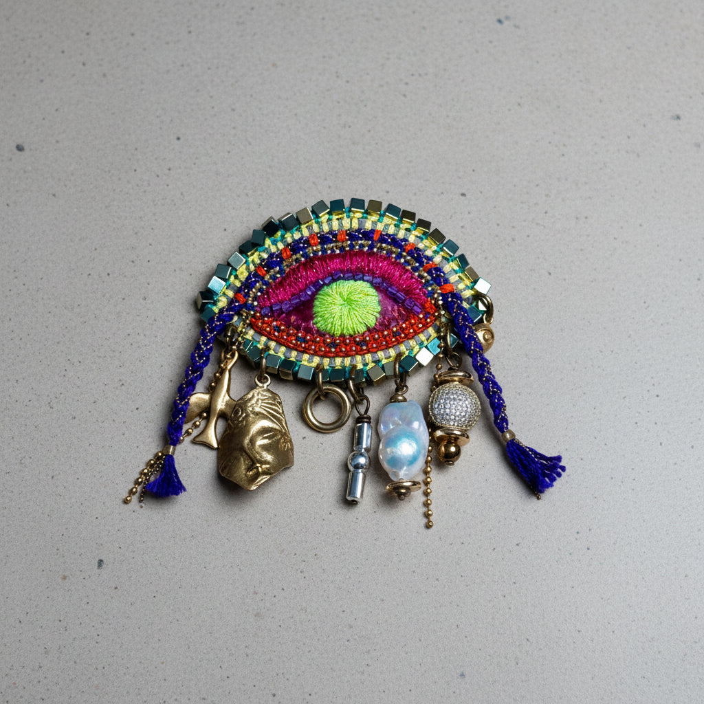 Colorful beaded eye-shaped decorative item with various charms on a brown background