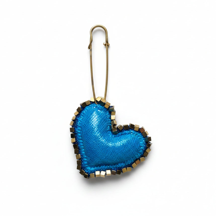 Blue heart-shaped keychain with a metal clip on a textured gray background