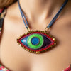 Colorful eye-shaped pendant necklace on a textured white background