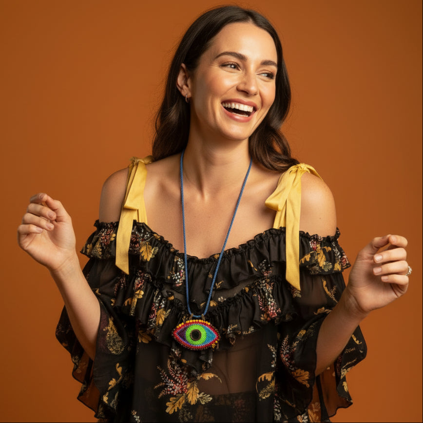 Mannequin wearing a black floral dress with a colorful necklace on a gray background
