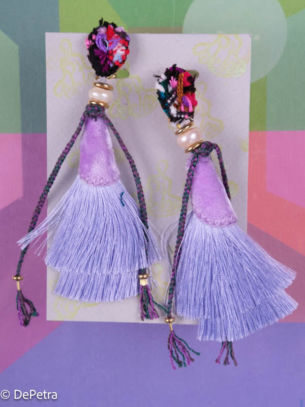 A whimsical and playful pair of earrings feature a long silk tassel. They are made of high-quality materials and are sure to turn heads wherever you go.